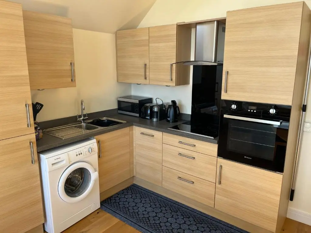 a kitchen with wooden cabinets and a washer at The Annexe in Lossiemouth