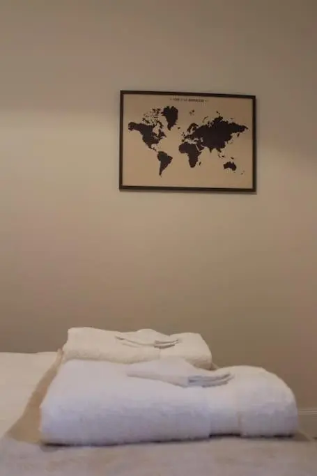 a pile of towels sitting on top of a bed at One bedroom Flat in Dingwall in Dingwall