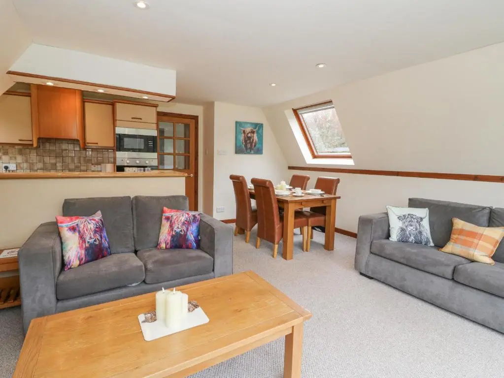 a living room with two couches and a table at Lodge 2 - Inglewood Lodge in Spean Bridge
