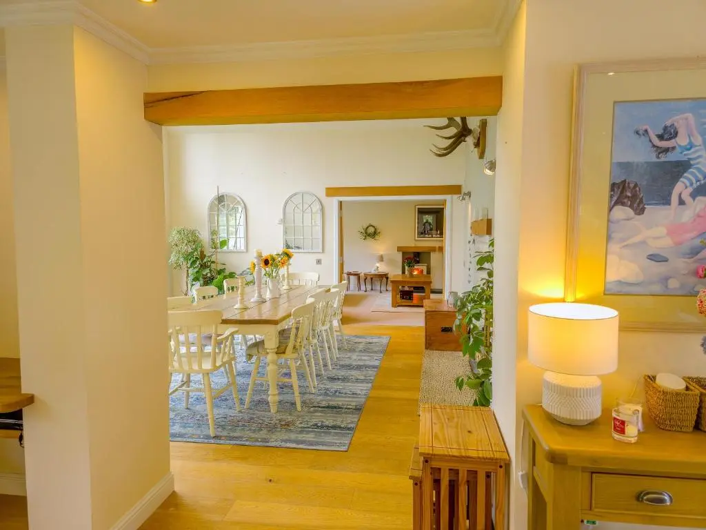 a dining room and living room with a table and chairs at The Bellhouse - hot tub lodge in Tomatin in Tomatin
