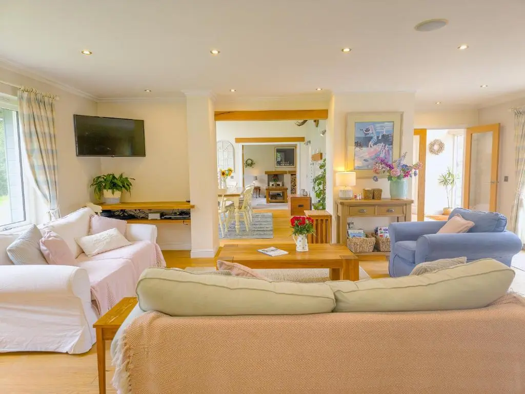 a living room with two couches and a tv at The Bellhouse - hot tub lodge in Tomatin in Tomatin