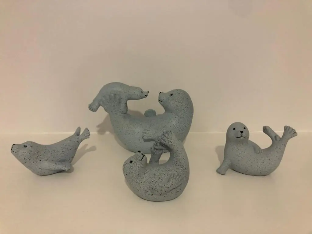 a group of four gray plastic figurines of seals at The Three Kings Inn in Cullen