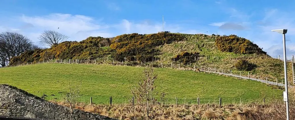 a grassy hill with a street light on top of it at The Three Kings Inn in Cullen