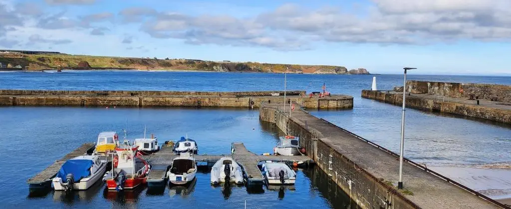 a group of boats are docked in a harbor at The Three Kings Inn in Cullen
