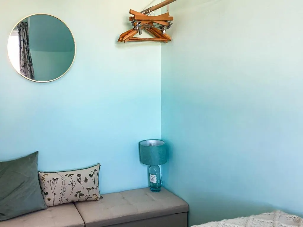 a mirror on a blue wall next to a couch at Taigh Na Tunnagan in Nairn