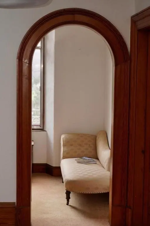 a living room with an archway with a couch and a window at Ardchoile in Kingussie