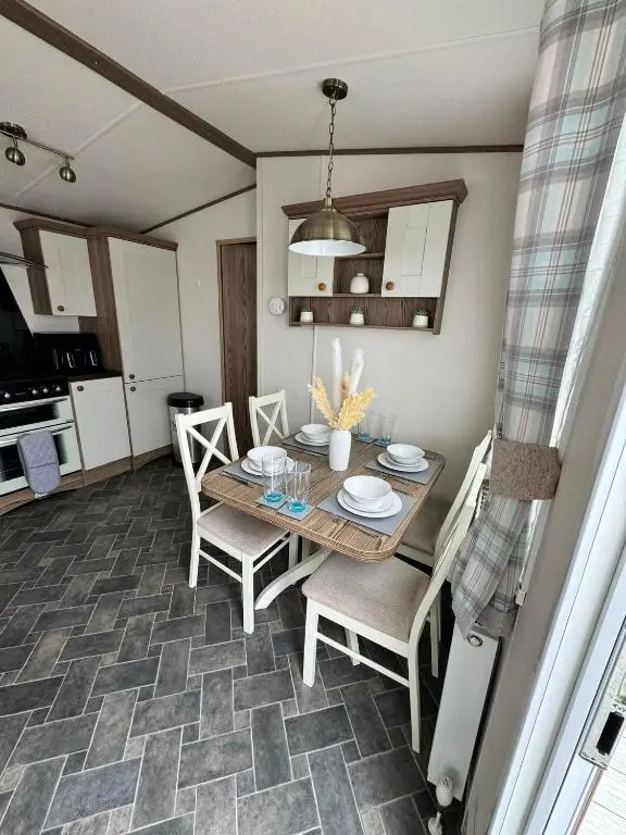 a dining room with a wooden table and chairs at Jandor Retreat in Lossiemouth
