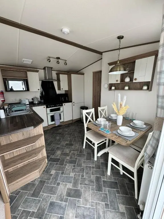 a kitchen and dining room with a table and chairs at Jandor Retreat in Lossiemouth