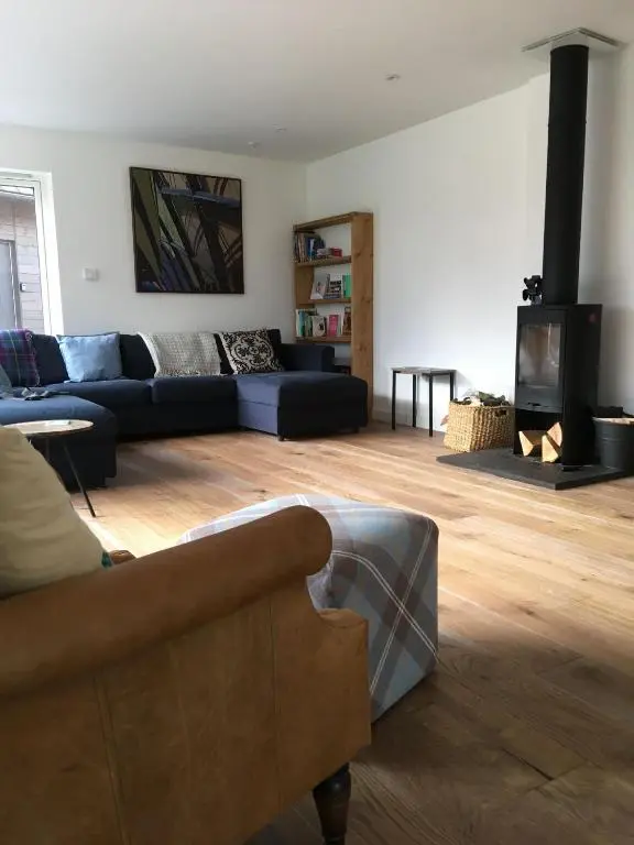 a living room with a couch and a fireplace at St Vincents in Kingussie