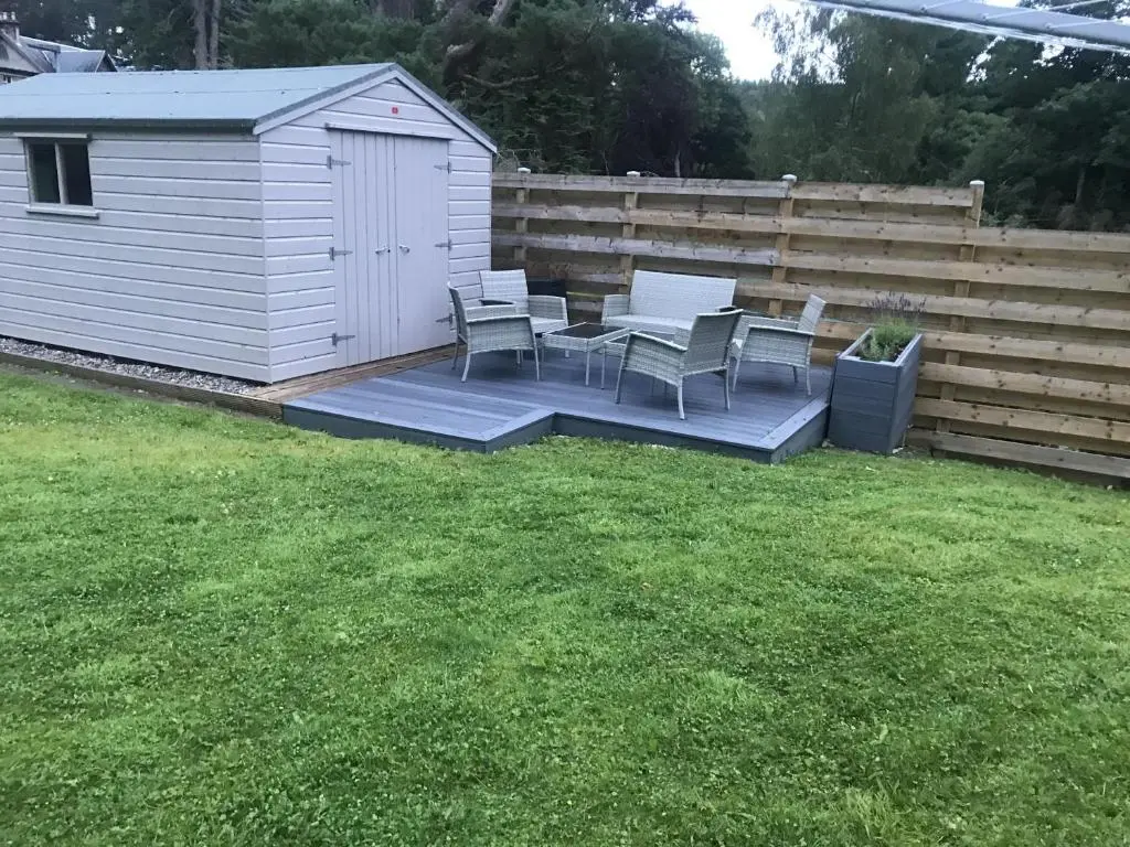 a backyard with a table and chairs and a fence at St Vincents in Kingussie