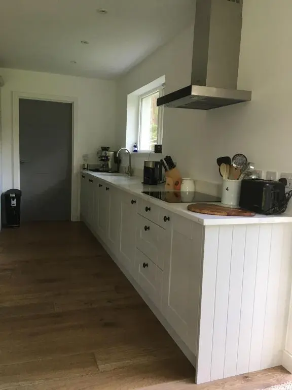 a kitchen with white cabinets and a counter top at St Vincents in Kingussie