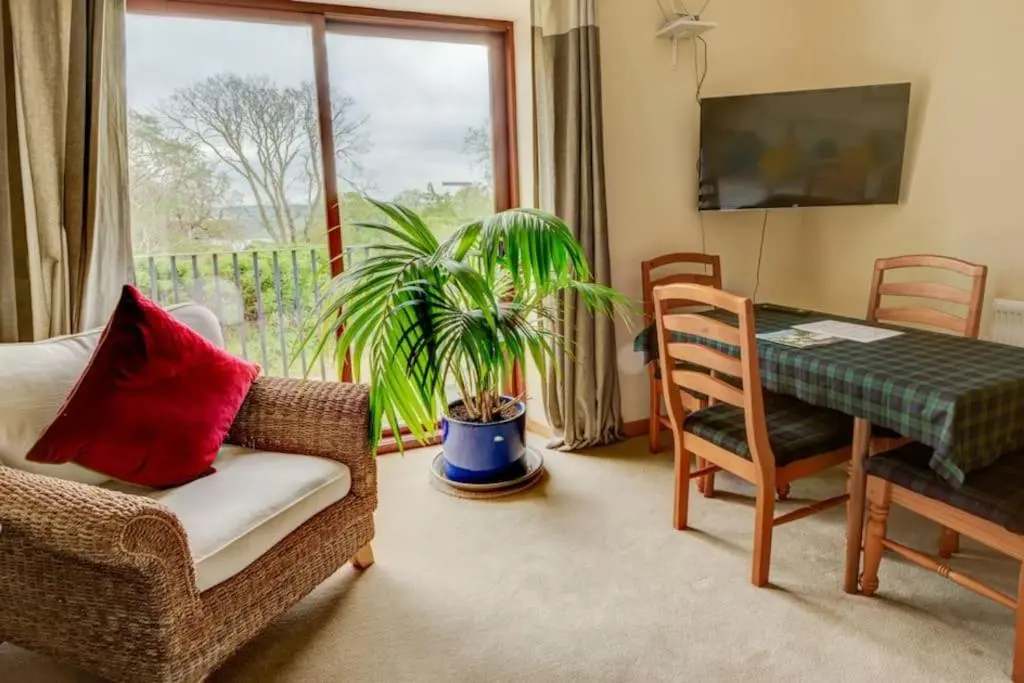 a living room with a table and a chair and a window at Foulis Cottage, Foulis Estate, Highland Scotland in Ardullie