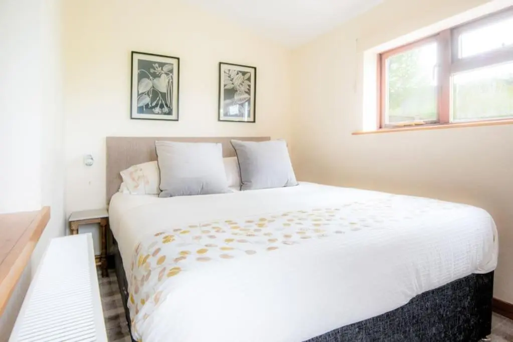 a large white bed in a room with a window at Foulis Cottage, Foulis Estate, Highland Scotland in Ardullie