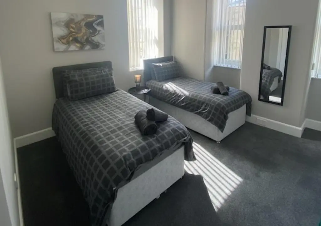 a bedroom with two beds and a mirror at Frithside Retreat 3BR Sleeps 7 Coastal Getaway in Fraserburgh