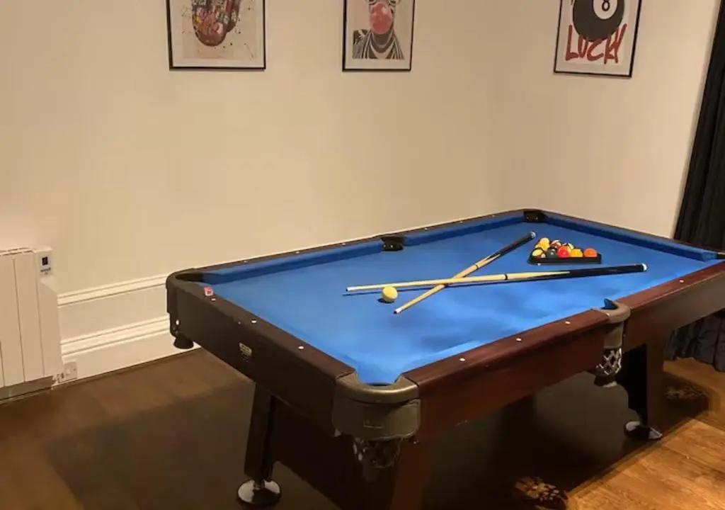 a pool table with two balls and two cuesticks at Frithside Retreat 3BR Sleeps 7 Coastal Getaway in Fraserburgh
