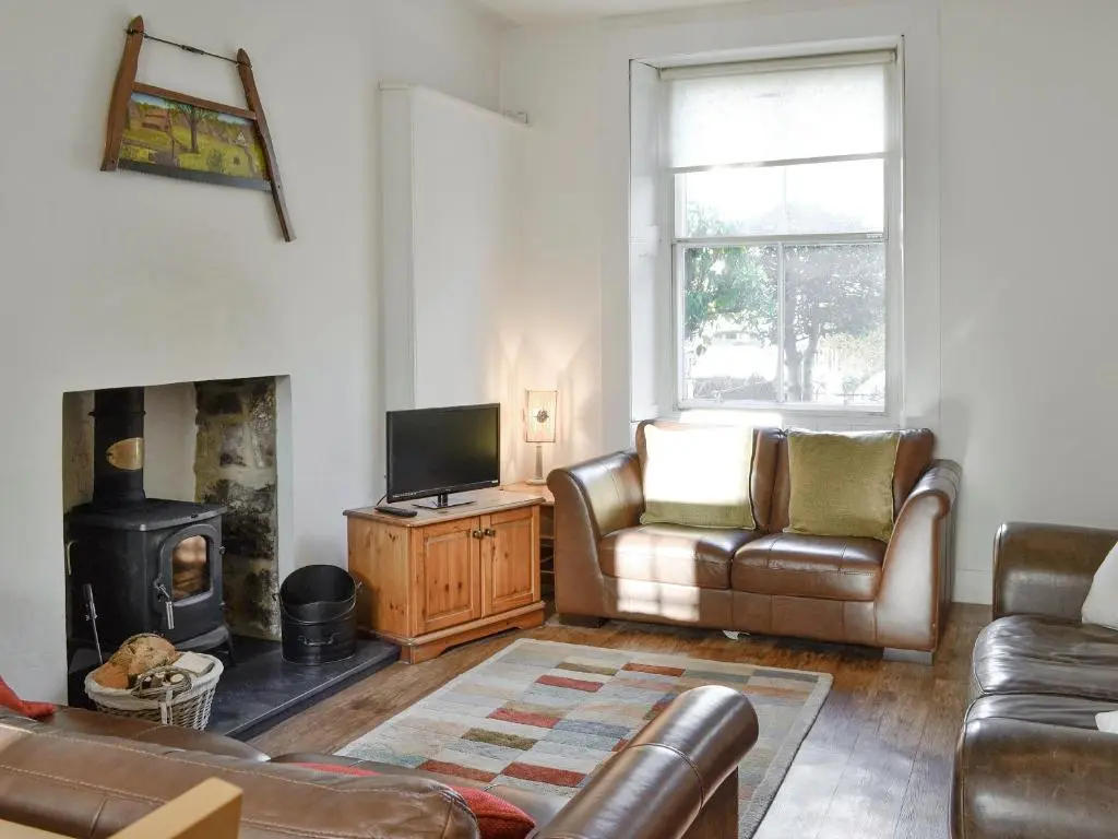 a living room with a couch and a fireplace at Viewington Lodge in Ballater