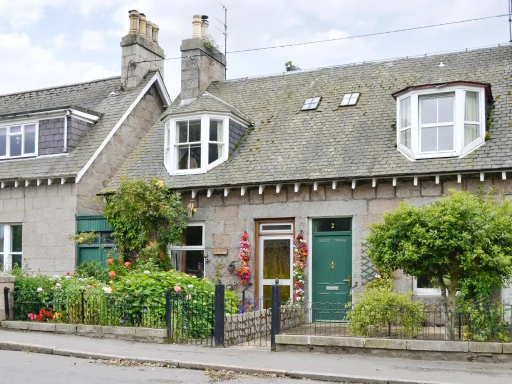 a house with a green door and a fence at Viewington Lodge in Ballater