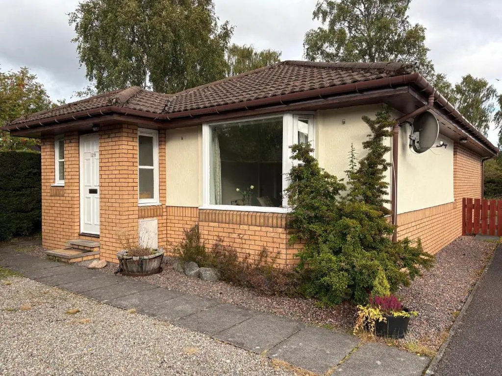 a small brick house with a large window at Craigie View Aviemore in Aviemore