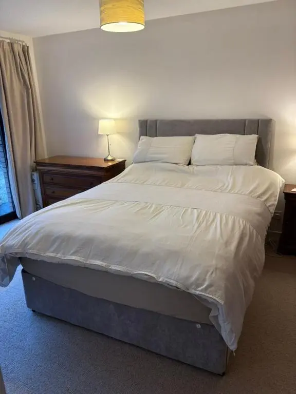 a bedroom with a large bed with white sheets and pillows at Craigie View Aviemore in Aviemore