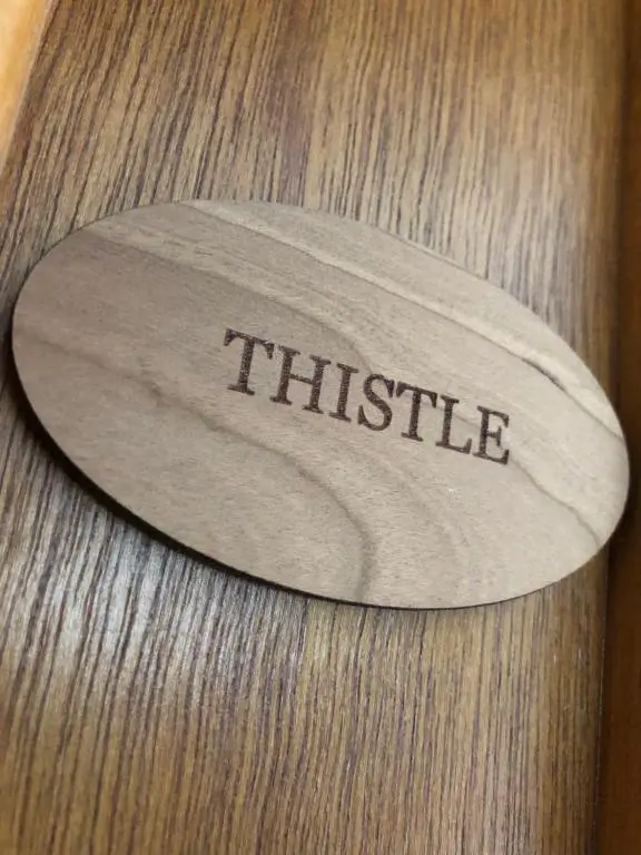 a wooden table with a plaque with the word hustle on it at Haus Alba in Grantown on Spey