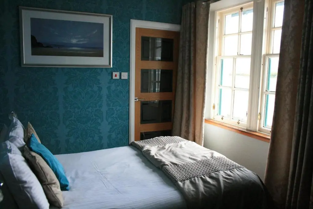 a bedroom with a bed in a room with a window at North Kessock Hotel in Inverness