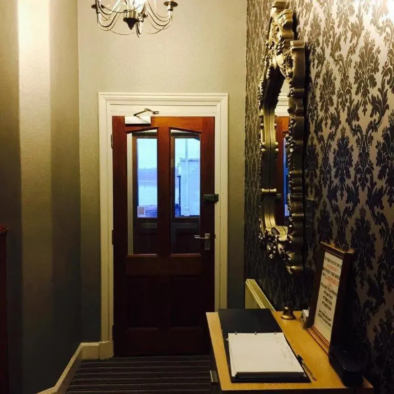 a room with a door and a table and a mirror at North Kessock Hotel in Inverness