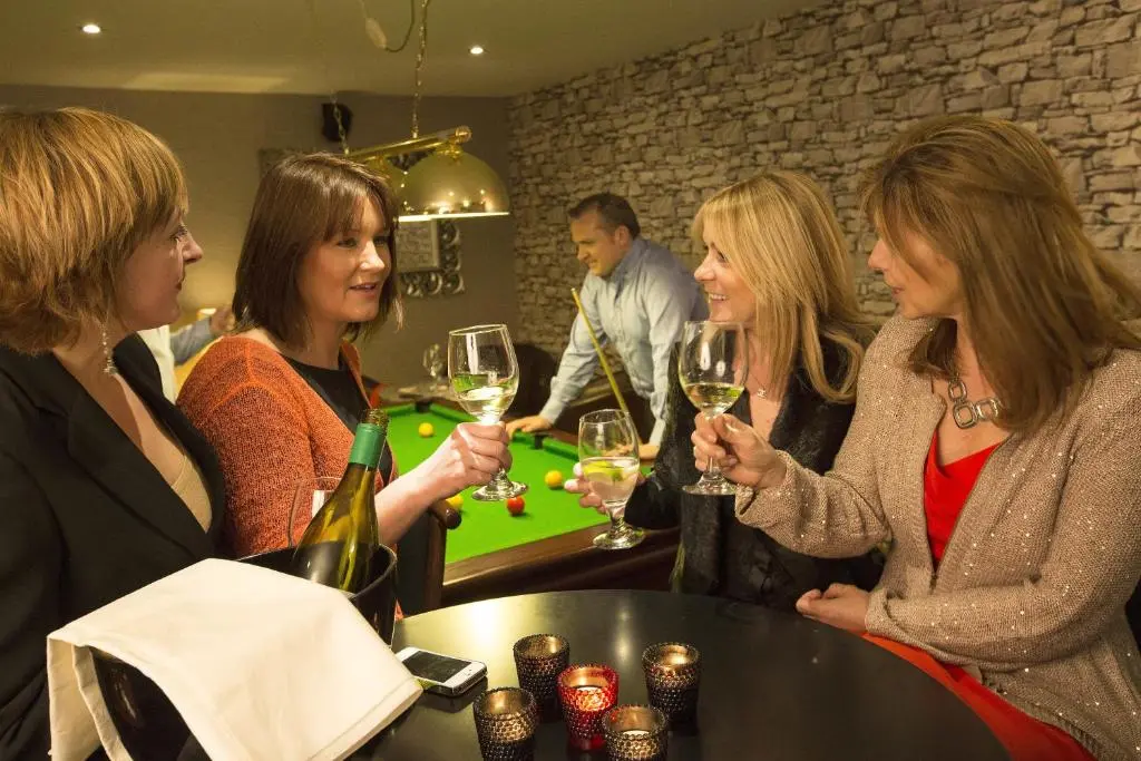 a group of women sitting at a bar drinking wine at North Kessock Hotel in Inverness