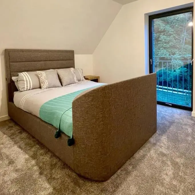 a large bed in a room with a large window at The Clearing in Huntly