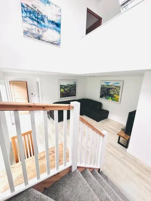 a room with a staircase and a living room at The Clearing in Huntly