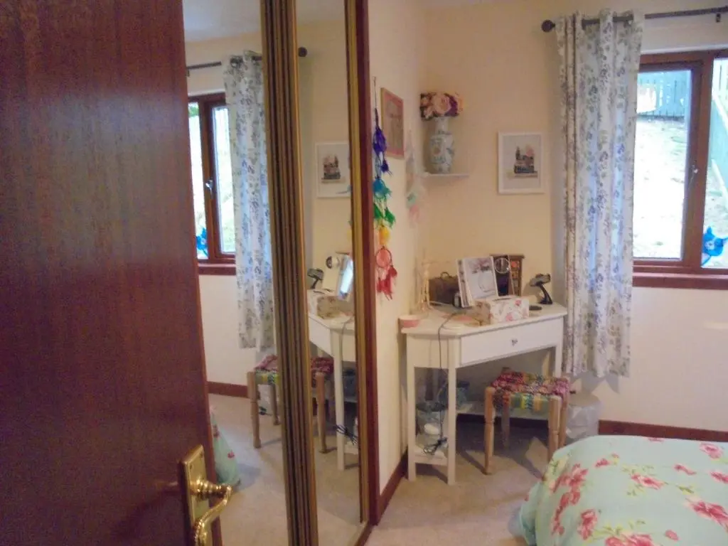 a bedroom with a mirror and a bed and a desk at 3 Station Court, Munlochy in Munlochy