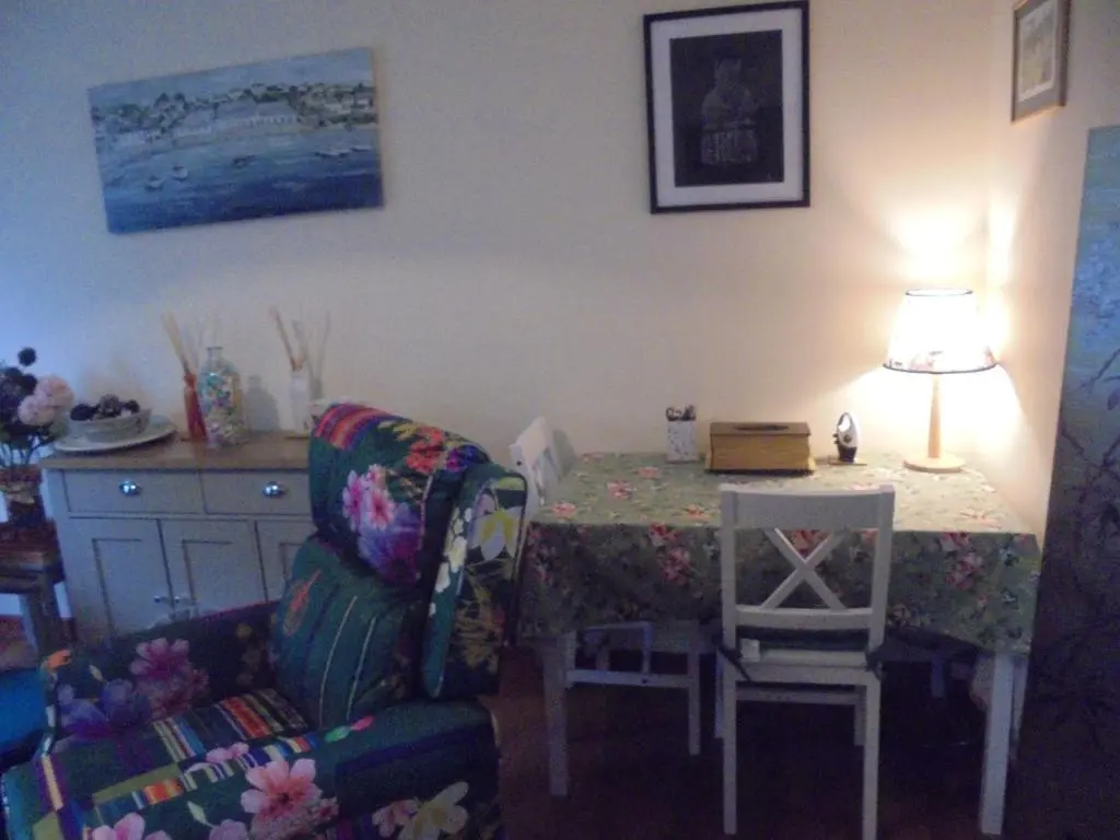 a living room with a table with a chair and a couch at 3 Station Court, Munlochy in Munlochy