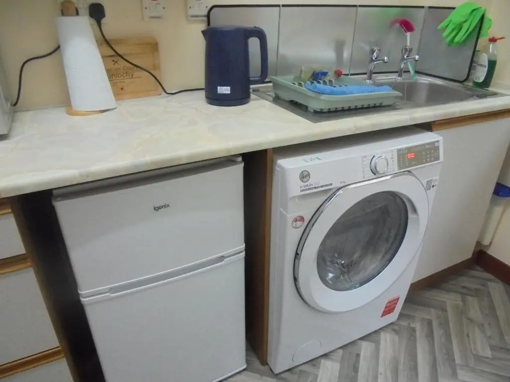 a kitchen with a washing machine and a sink at 3 Station Court, Munlochy in Munlochy