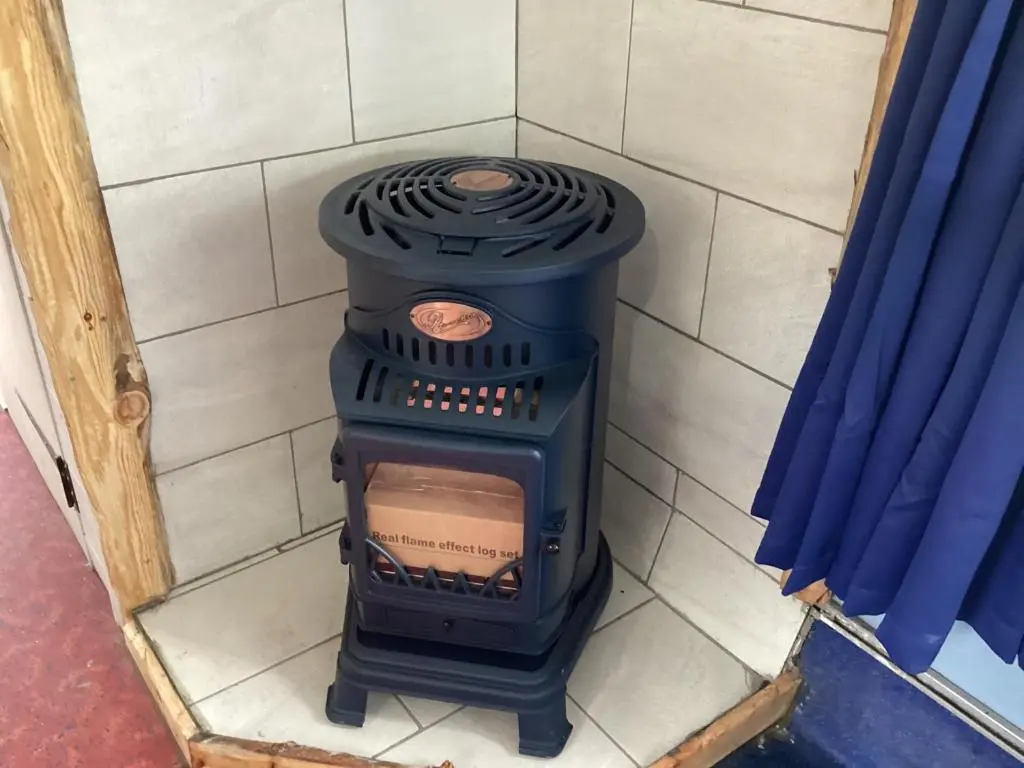 a black stove in a corner of a room at Archie The Double Decker Bus in Tain