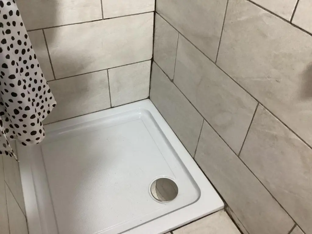 a shower with a drain in the floor of a bathroom at Archie The Double Decker Bus in Tain
