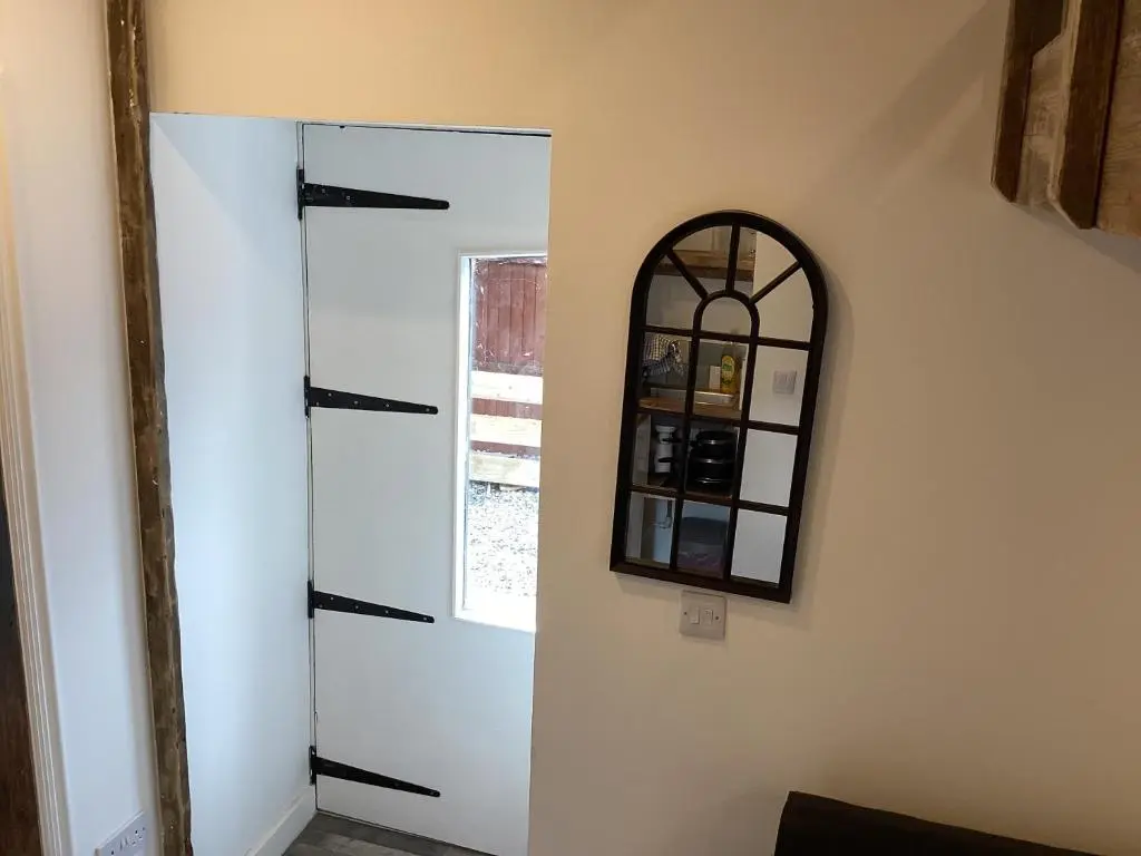 a mirror on a wall next to a white wall at The Wee Bothy in Tain