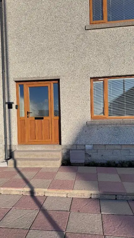 a building with a wooden door and two windows at No 67 West Road in Fraserburgh