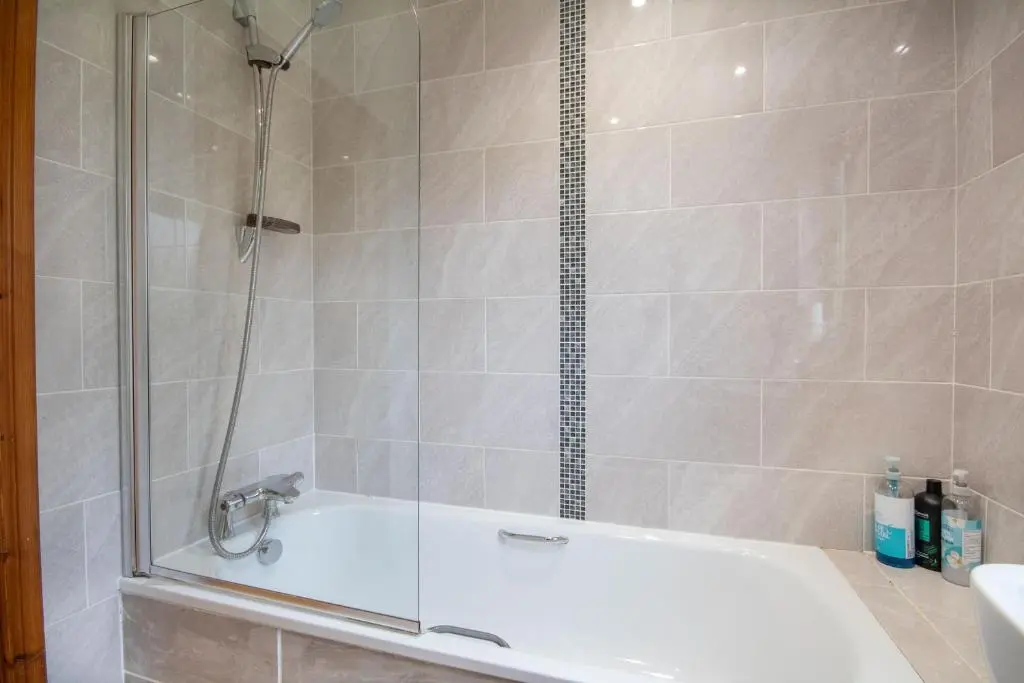 a bathroom with a shower with a white tub at Boutique Four Bed Holiday Home in Inverness in Inverness