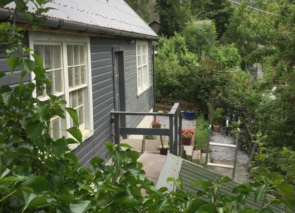 a small house with a porch and a window at Ullapool Lawyur's patch in Ullapool