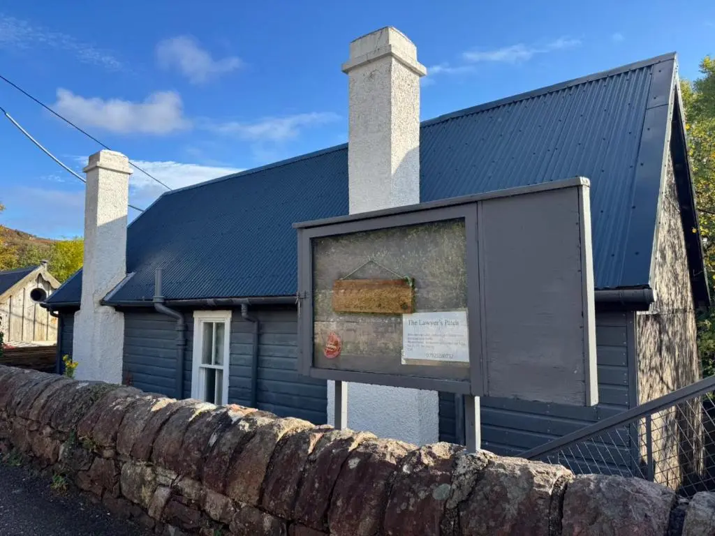 a building with a sign in front of it at Ullapool Lawyur's patch in Ullapool