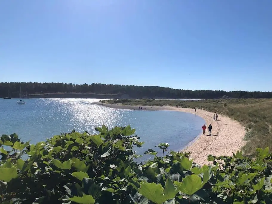 two people walking on a beach near the water at Calailan Highland Seaside Retreat - Nairn in Nairn