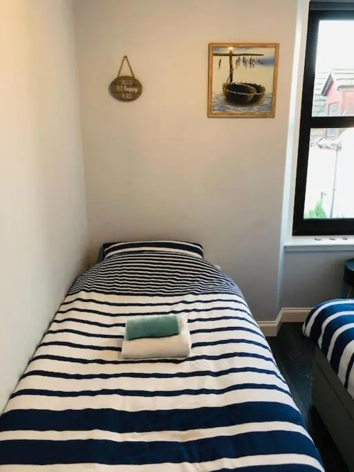 a blue and white striped bed in a room at Calailan Highland Seaside Retreat - Nairn in Nairn