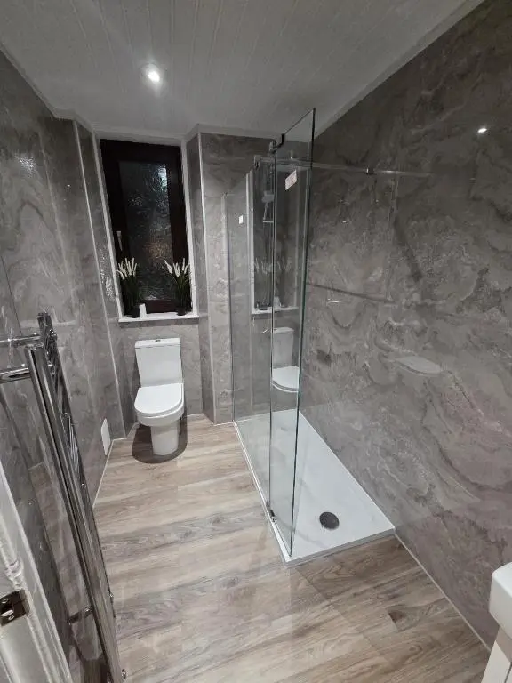 a bathroom with a toilet and a glass shower at Calailan Highland Seaside Retreat - Nairn in Nairn