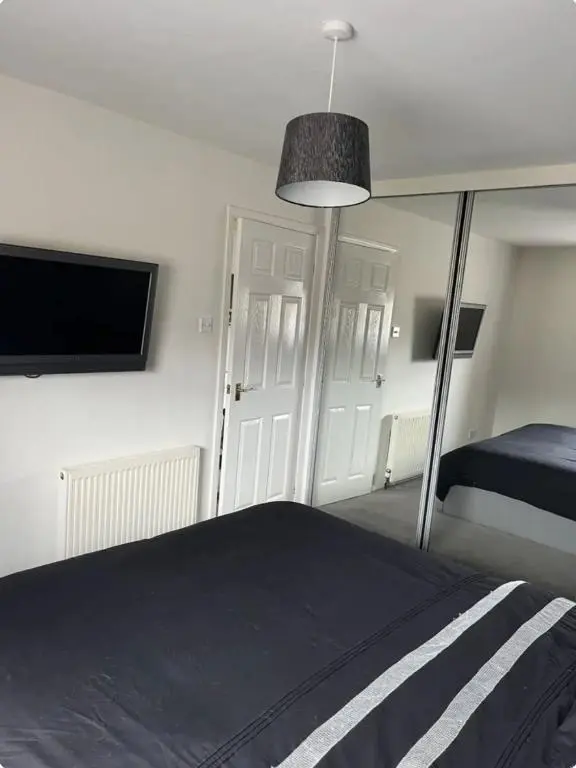 a bedroom with a bed and a flat screen tv at Townhead Road in Inverurie