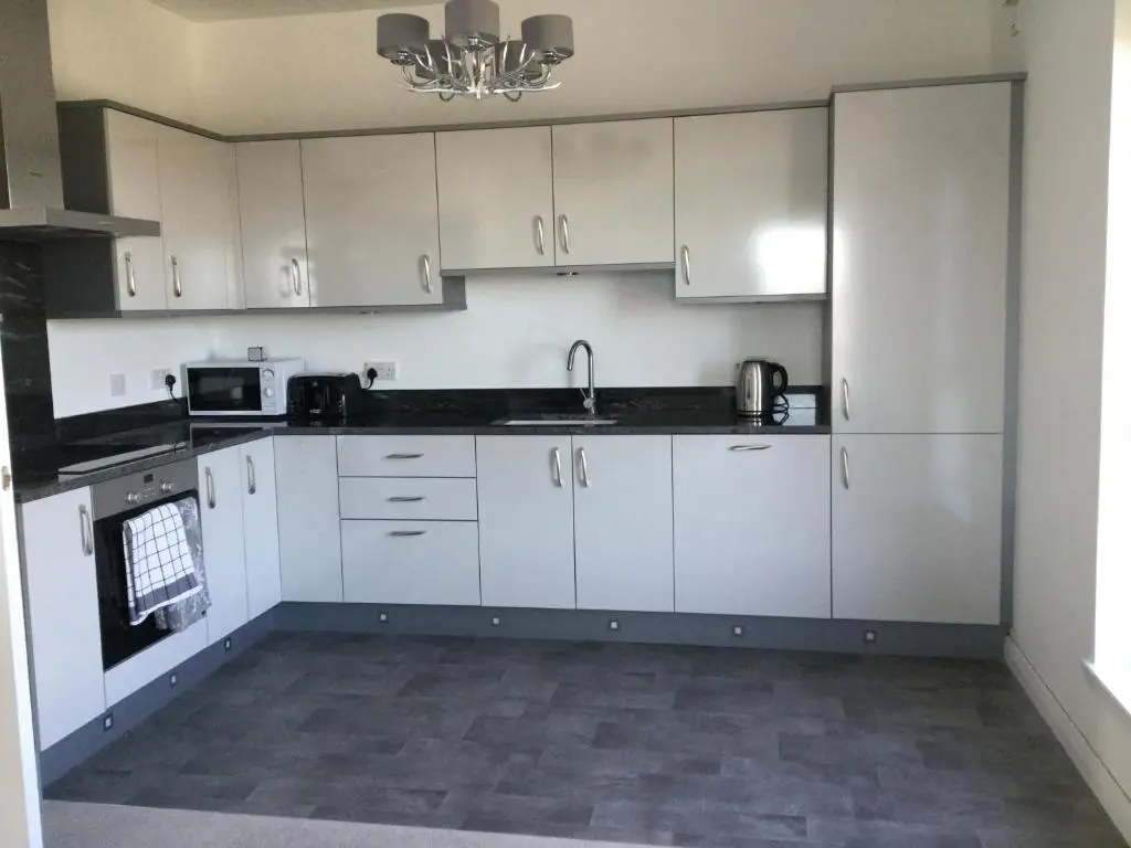 a kitchen with white cabinets and a sink at Amazing views of Inverness in Inverness