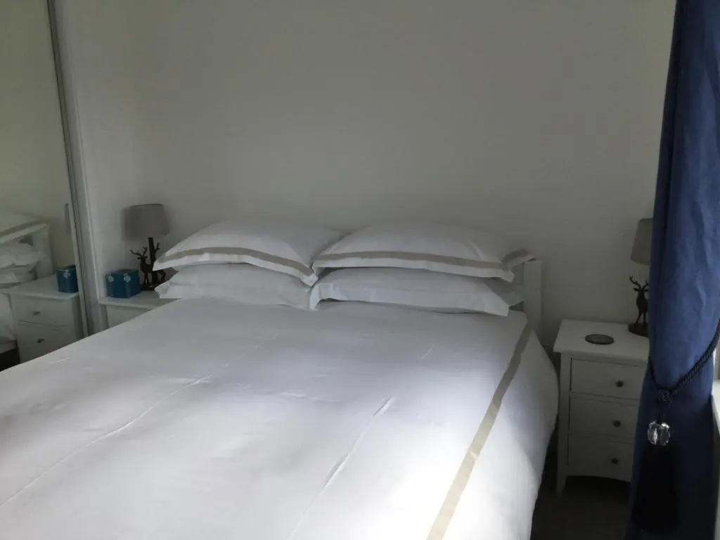 a white bed with four pillows in a bedroom at Amazing views of Inverness in Inverness