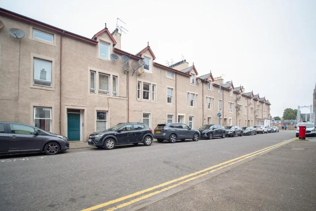 a row of cars parked on the side of a street at Comfortable 2-Bedroom Inverness Flat in Inverness