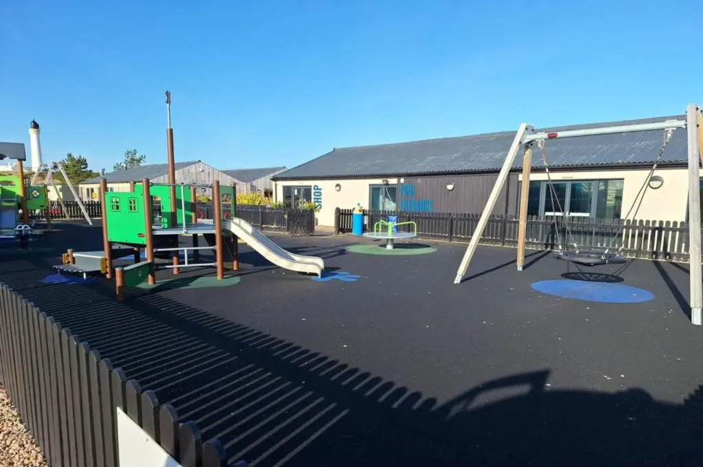 a playground with two swings and a slide at Lewis Sands PC114 in Lossiemouth