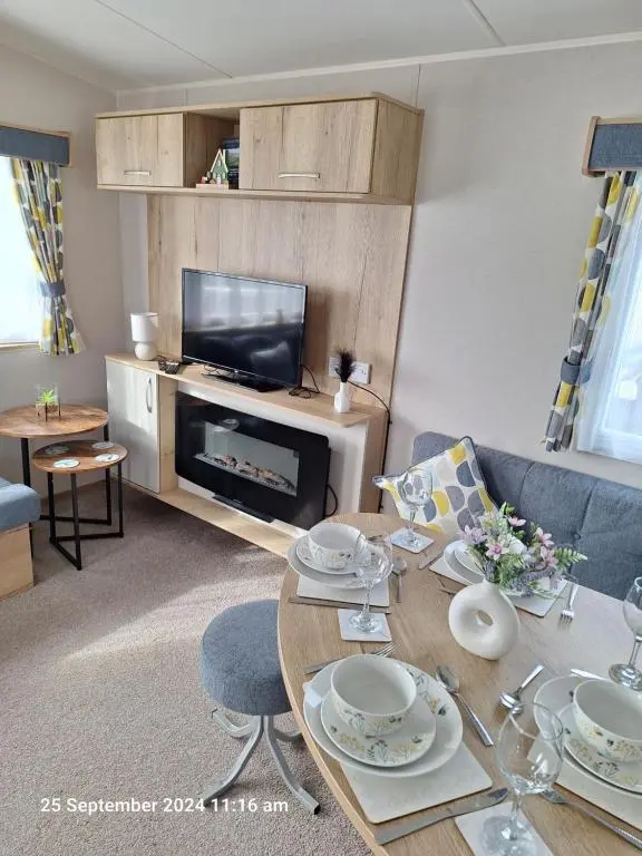 a living room with a table and a television at Lewis Sands PC114 in Lossiemouth