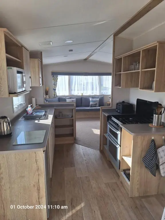 a kitchen with wooden cabinets and a stove top oven at Lewis Sands PC114 in Lossiemouth