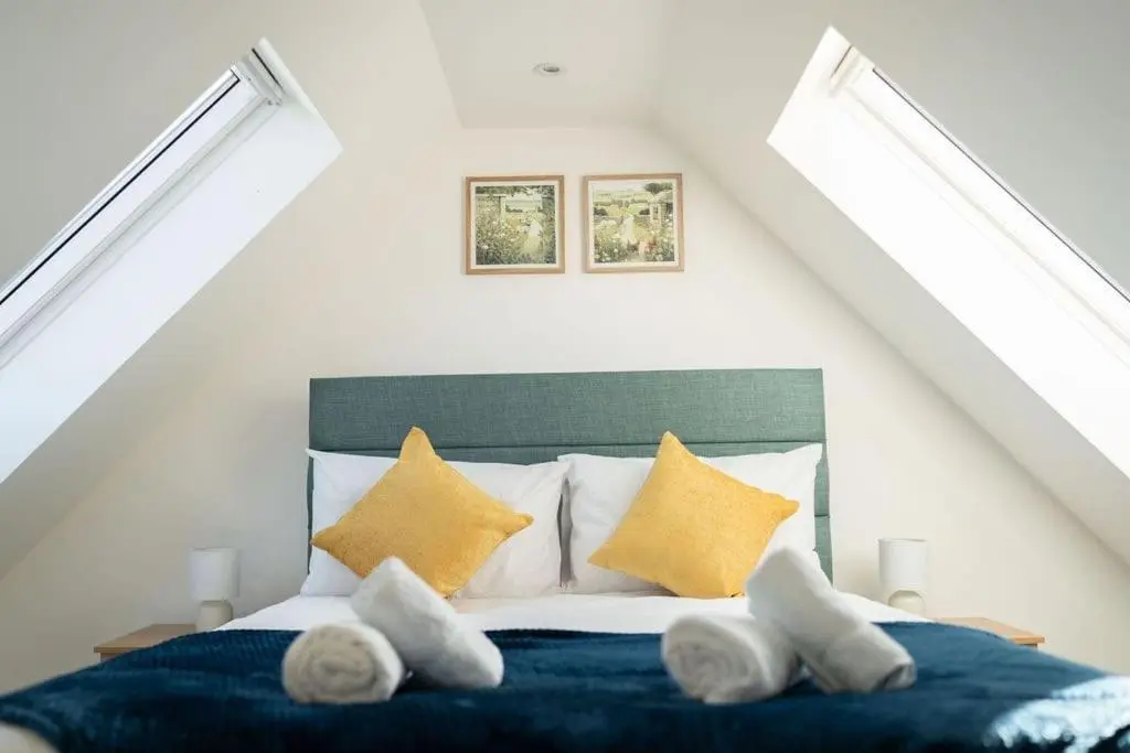 a bedroom with a bed with yellow pillows at Easter Cottage -4 Bed Converted Barn Cottage in Turriff